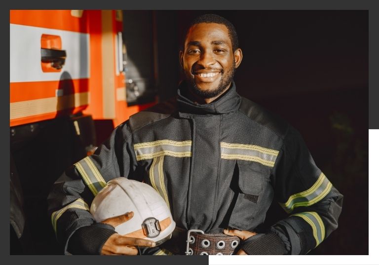 firefighter holding helmet smiling