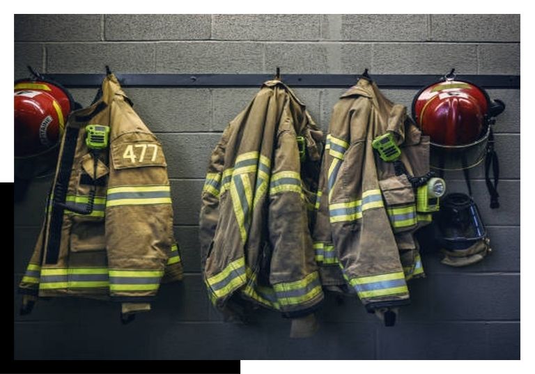 firefighter jackets and helmets hung up on wall