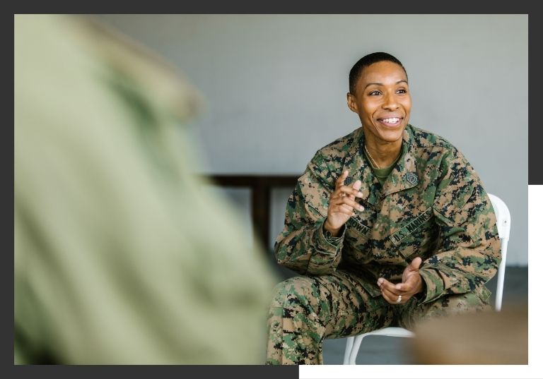military professional sitting in chair smiling