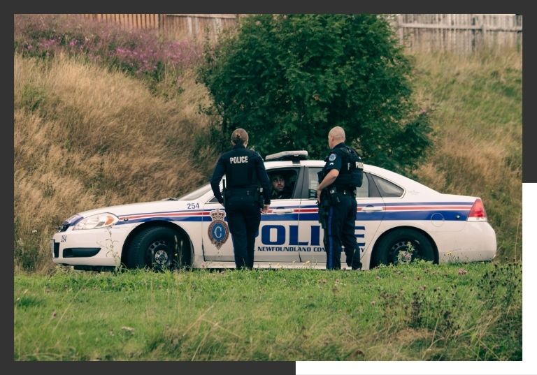 police officers standing outside of police car
