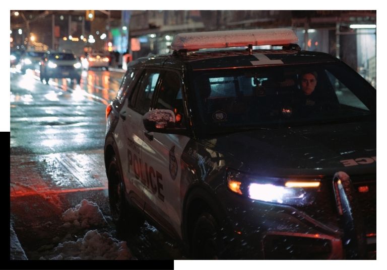 police car driving down road at night