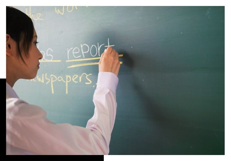 teacher writing on chalk board